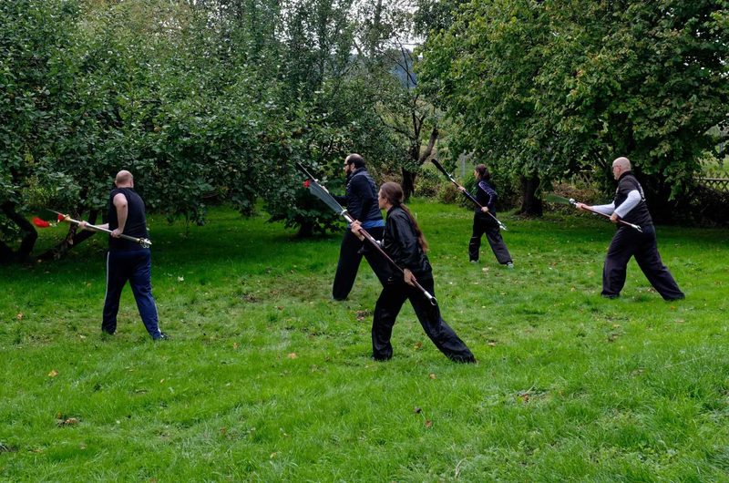Schüler üben die Hellebardenform Kwan Do unter Anleitung des Meisters